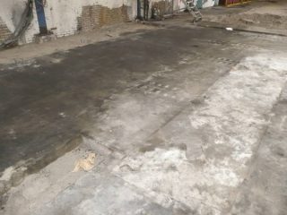 Een zwaar vervuilde betonvloer voorafgaand aan de vloer renovatie