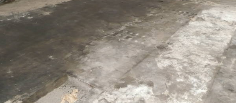 Een zwaar vervuilde betonvloer voorafgaand aan de vloer renovatie